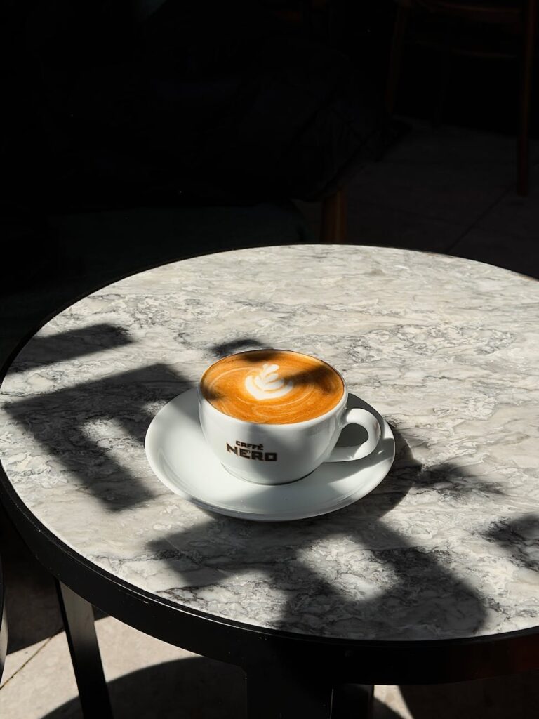 latte art on a sunlit cafe table